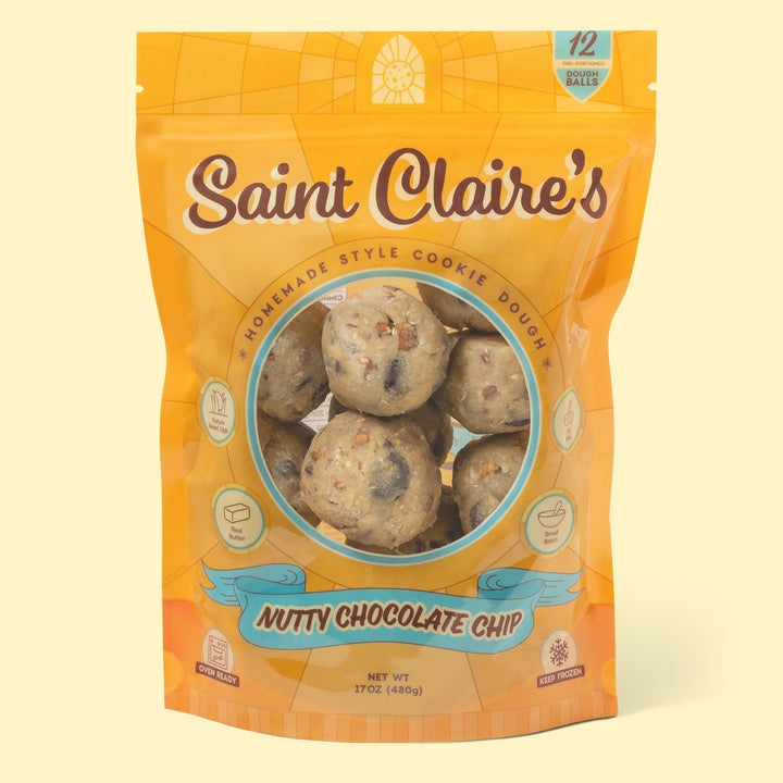 A pack of Saint Claire's Nutty Chocolate Chip cookie dough, showing the package which is predominantly orange with an image of the cookies through a clear window.
